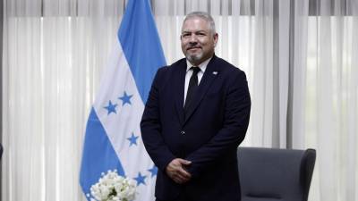 El canciller de Honduras, Eduardo Enrique Reina, posa de pie en su oficina.