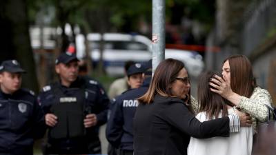 Profesoras consuelan a una estudiante después de que nueve personas murieran y varias resultaran heridas en una escuela de Belgrado, Serbia.