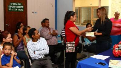 Uno de los beneficiados recibe el préstamo de manos de Francis Rodríguez.