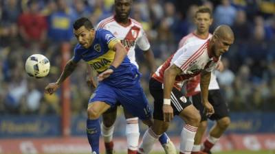 Carlos Tévez supera la marca de Jonathan Maidana. Foto AFP/Juan Mabromata