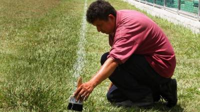 Empleado del Inmude pinta la cancha de fútbol del complejo Patria-Marathón.