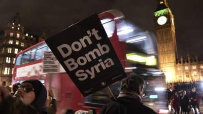 Protestas contra la guerra se llevaron a cabo frente a la sede del Parlamento en la capital inglesa. La pancarta lee 'No bombardeen Siria'.