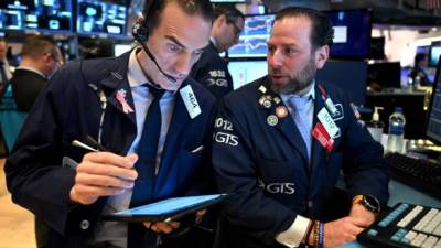 Los corredores de Wall Street se lamentan tras el cese de operaciones por la caída de las bolsas./AFP.