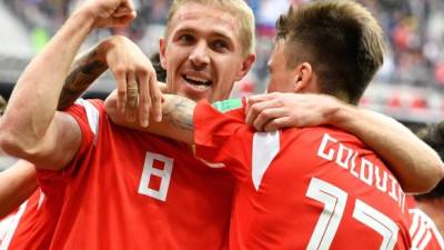 Russia's midfielder Yuri Gazinskiy (L) celebrates scoring the opening goal with his teammates during the Russia 2018 World Cup Group A football match between Russia and Saudi Arabia at the Luzhniki Stadium in Moscow on June 14, 2018. / AFP PHOTO / Alexander NEMENOV / RESTRICTED TO EDITORIAL USE - NO MOBILE PUSH ALERTS/DOWNLOADS