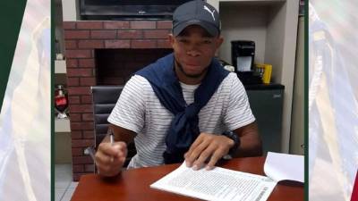 Carlos Róchez muy contento firmando su contrato con el Marathón.