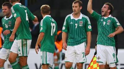 A man walks his dog past a sign encouraging social distancing in Phoenix Park as Ireland's Taoiseach Leo Varadkar has introduced a number of sweeping measures to tackle the coronavirus, including restricting all public gatherings to four people, in Dublin, Wednesday March 25, 2020. (Brian Lawless/PA via AP)