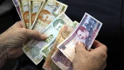 Un usuario cuenta varios billetes de lempira.