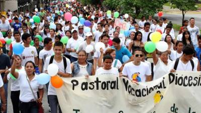 Cientos de jóvenes de la pastoral vocacional de la Diócesis de San Pedro Sula mientras caminaban ayer por la mañana por la primera calle, en el barrio Los Andes.