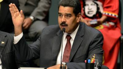 Supporters of Venezuelan President Nicolas Maduro hold a portrait of him in a ceremony to swear him in symbolically in front of the National Assembly building during a rally around the city in Caracas, Venezuela on January 7, 2019. - Maduro has presided over a spiraling political and economic crisis in Venezuela since taking over from his mentor, the late leftist firebrand Hugo Chavez, in 2013. (Photo by YURI CORTEZ / AFP)