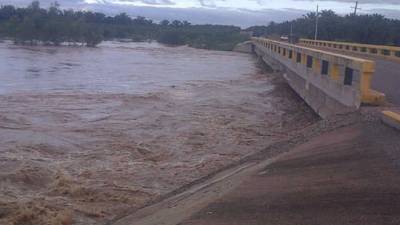 A man rides his bike under the rain in the municipality of Omoa, about 210 km northwest of Tegucigalpa, on November 11, 2017.The rainy season in Honduras, which goes from April to November, has killed at least 43 people. / AFP PHOTO / Orlando SIERRA