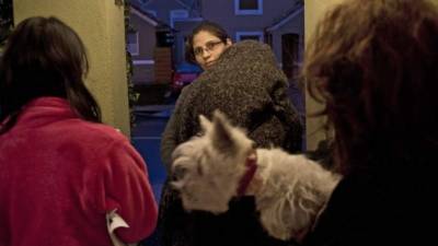 Una familia espera en las afueras de su casa luego del terremoto en Santiago.