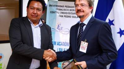 El vicerrector de la Universidad Pedagógica, José Aguilar, entrega un reconocimiento al catedrático brasileño Valdir Barzotto.