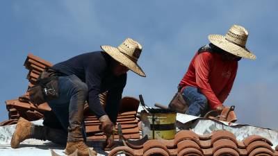 Dos personas trabajan en el techo de una Iglesia en Arizona.