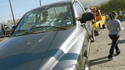 A bullet riddled pick-up truck is towed after unknown gunmen opened fire on it, killing a man and a woman, in Tijuana, Mexico, Tuesday, March 24, 2009. The Obama administration says it is sending more agents and equipment to the southwestern U.S. border to combat Mexican drug cartels. (AP Photo)