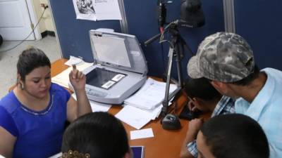 Empleada de Migración y Extranjería toma los datos de un ciudadano que solicita el pasaporte. Foto: Amilcar Izaguirre.