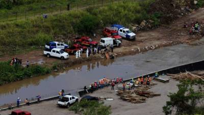 Miembros del Cuerpo de Bomberos rescatan en el río Choluteca el cadáver de Mario Efraín Cruz.