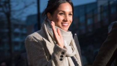 Fiancée of Britain's Prince Harry's, US actress Meghan Markle waves to well-wishers as they leave after a visit to Reprezent 107.3FM community radio station in Brixton, south west London on January 9, 2018.During their visit to the station, they met some of the presenters, content producers and staff, heard more about their training programmes, and met some of the current and former volunteers who have benefitted from the training. / AFP PHOTO / POOL / Dominic Lipinski