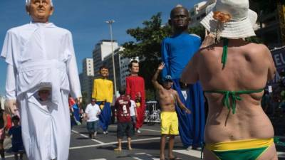 Una turista toma fotos a la figura del Papa Francisco en las playas de Copacabana, Brasil.