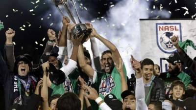 Raúl González (centro) celebra con sus compañeros junto al trofeo de campeones. Foto EFE