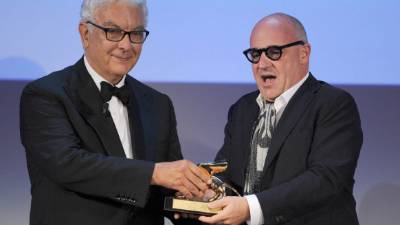FRR90. Venice (Italy), 07/09/2013.- Italian director Gianfranco (R) recives the Golden Lion Award for the movie 'Sacro GRA' (Holy GRA), from Venice Biennale President Paolo Baratta, during the closing award ceremony of the 70th Venice International Film Festival in Venice, Italy, 07 September 2013. Sacro GRA is an Italian documentary about people living and working around the GRA, Rome's motorway ring road. The winning feature offers a multi-faceted picture of life on the outskirts of the Italian capital, focusing on ambulance workers, prostitutes, council flat tenants, fishermen and eccentric aristocrats. EFE/EPA/ETTORE FERRARI