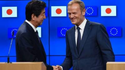 European Council President Donald Tusk (R) shakes hands with Japanese Prime Minister Shinzo Abe (L) during a press conference after an EU-Japan summit at the European Council on July 6, 2017, in Brussels.Japanese Prime Minister Shinzo Abe and top EU officials agreed on July 6 to the broad outline of a landmark trade deal, presented as a direct challenge to protectionism championed by US President Donald Trump. / AFP PHOTO / JOHN THYS