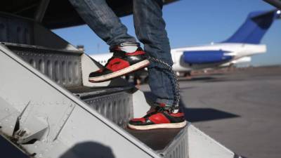 Un inmigrante hondureño aborda un avión del ICE para ser deportado a su país.