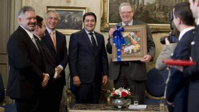El presidente de Honduras, Juan Orlando Hernández (4i) le entrega el cuadro de un pintor hondureño al Gran Maestro de la soberana Orden de Malta, Fra' Matthew Festing (5i), durante la reunión que mantuvieron en Roma, donde suscribieron un convenio de colaboración. EFE