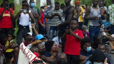 Haitian and Central American migrants protest outside the Siglo XXI Migratory Station, in Tapachula, Chiapas state, Mexico, on September 15, 2021. - The new migratory flow of Haitians to the United States seems to be encouraged by friends and relatives who tell them about the benefits of living in the North. But no one warns them of the ordeal they will face first. In addition to thousands of kilometres of road, the journey to southern Mexico, from where they will try to flee to the promised land, includes days of walking through mountains and jungles infested with insects and animals, assaults by criminal groups and shipwrecks. (Photo by CLAUDIO CRUZ / AFP)