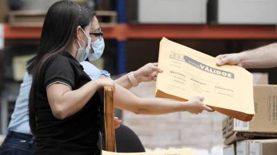 Personal del Tribunal Supremo de Elecciones de Costa Rica empacan en sacos las papeletas electorales que serán distribuidas el próximo 6 de febrero, día de las elecciones, en una fotografía de archivo.