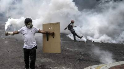 A man suffers from the effects of tear gas thrown by the National Guard to prevent anti-government demonstrators from gathering at Altamira Square in Caracas to protest against Venezuelan President Nicolas Maduro, on June 14, 2017.With Venezuelans suffering from high inflation, food shortages and soaring crime rates, plus a deepening corruption scandal, the Venezuelan opposition has mounted near-daily anti-government protests since April 1. The protests have left 68 dead so far and more than a thousand injured, according to prosecutors. / AFP PHOTO / Federico PARRA