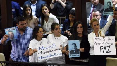 (FILES) In this file photo taken on March 08, 2018 members of the emergency services in green biohazard encapsulated suits arrive to afix the tent over the bench where a man and a woman were found on March 4 in critical condition at The Maltings shopping centre in Salisbury, southern England, after the tent became detached. A British couple left critically ill in an English village were exposed to Novichok -- the same nerve agent used in the poisoning of a former Russian spy and his daughter in the nearby city of Salisbury this year, police said on July 4, 2018. Counter-terrorism police are now leading the investigation into the incident after tests at the Porton Down defence laboratory confirmed the nature of the substance, which Britain says is a Soviet-made military grade nerve agent. / AFP PHOTO / Ben STANSALL