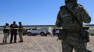 Integrantes de la policía y del ejercito custodian la zona donde fue hallado el cuerpo sin vida de un migrante este viernes, en ciudad Juárez, estado de Chihuahua (México).