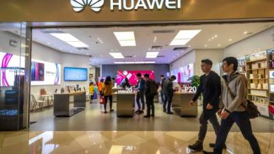 Personas caminan frente a la tienda de Huawei en Guangzhou (China). EFE