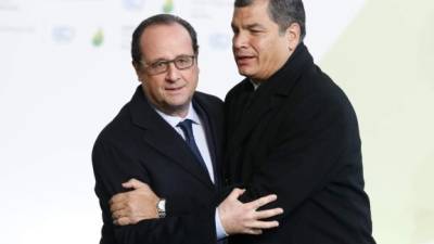 El presidente de Ecuador, Rafael Correa (der.) se abraza con su homólogo francés, Francois Hollande durante la cumbre sobre cambio climático en París.