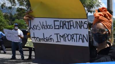 Una mujer garífuna sostiene un letrero que dice 'Los garífunas también importan' durante una protesta frente a la Corte Suprema de Justicia en Tegucigalpa. AFP