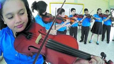Siete estudiantes de la Victoriano López practican el violín en las instalaciones del centro.
