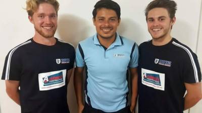 El joven tico Luis Ruiz con dos australianos de su academia de fútbol.