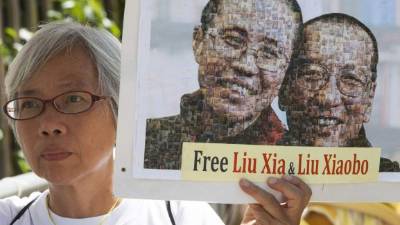 Las autoridades chinas no permitieron a Xiabo buscar ayuda médica en el extranjero para ser tratado por su cáncer. En imagen una mujer participa en una concentración por la liberación del nobel de la Paz, quien agonizaba en un hospital bajo fuertes medidas de seguridad.// Foto EFE/ALEX HOFFORD