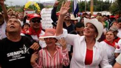 FILE - In this May 1, 2010 file photo, Xiomara Castro Zelaya, right, wife of former Honduras President Manuel Zelaya, waves to supporters during a Labor Day rally in Tegucigalpa, Honduras. The political parties of Honduras are holding primary elections on Sunday, Nov. 18, 2012, as Castro's newly created party, the Libre, or Free party, is trying to break the country's 114- year-old two party system. (AP Photo/Fernando Antonio, file)