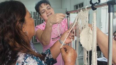 <b>Dos mujeres aprenden a elaborar productos artesanales durante un taller para fomentar el emprendimiento.</b>