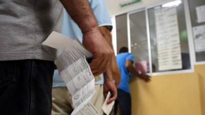 Un afiliado hace la fila para presentar su hoja vigente.