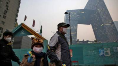 Un padre y su hijo usan mascarillas para protegerse de la contaminación ambiental en Pekín (China), hoy, 7 de diciembre de 2015. EFE