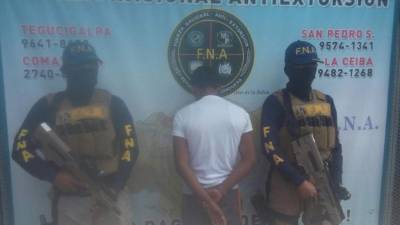 Menor acusado del delito de extorsión es custodiado por agentes de la FNA, tras detenerlo en la capital.