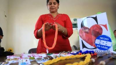 Sandra Alvarado, una microempresaria, confecciona collares y bisutería en una exhibición organizada por la Anmpih.