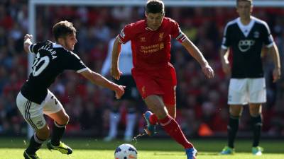 Steven Gerrard, capitán del Liverpool, supera a Adam Lallana del Southampton.