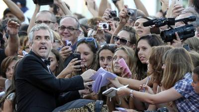 El director mexicano Alfonso Cuarón firma autógrafos a su llegada para el estreno de la película 'Gravity', en Venecia.