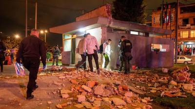Especialistas en explosivos que inspeccionan el CAI donde explotó un artefacto en Bogotá (Colombia).