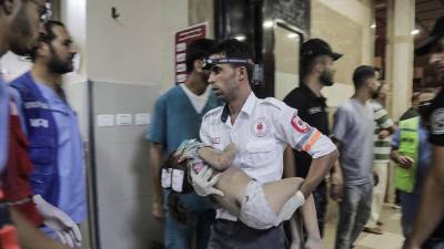 Un paramédico lleva a un niño herido a un hospital tras un bombardeo en la Franja de Gaza.