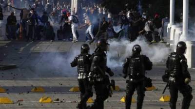 Manifestantes enfrentan a la Policía durante el desarrollo de las protestas y movilizaciones por el denominado Paro Nacional este jueves, en Cali (Colombia).