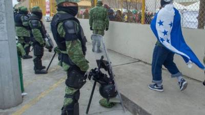 Un hondureño envuelto en una bandera nacional camina hasta un refugio para migrantes centroamericanos en Piedras Negras, estado de Coahuila. AFP